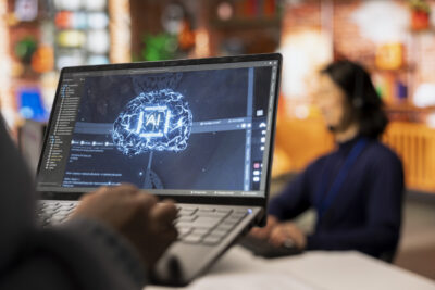 Call center worker using AI tech on laptop to reply to customers, closeup